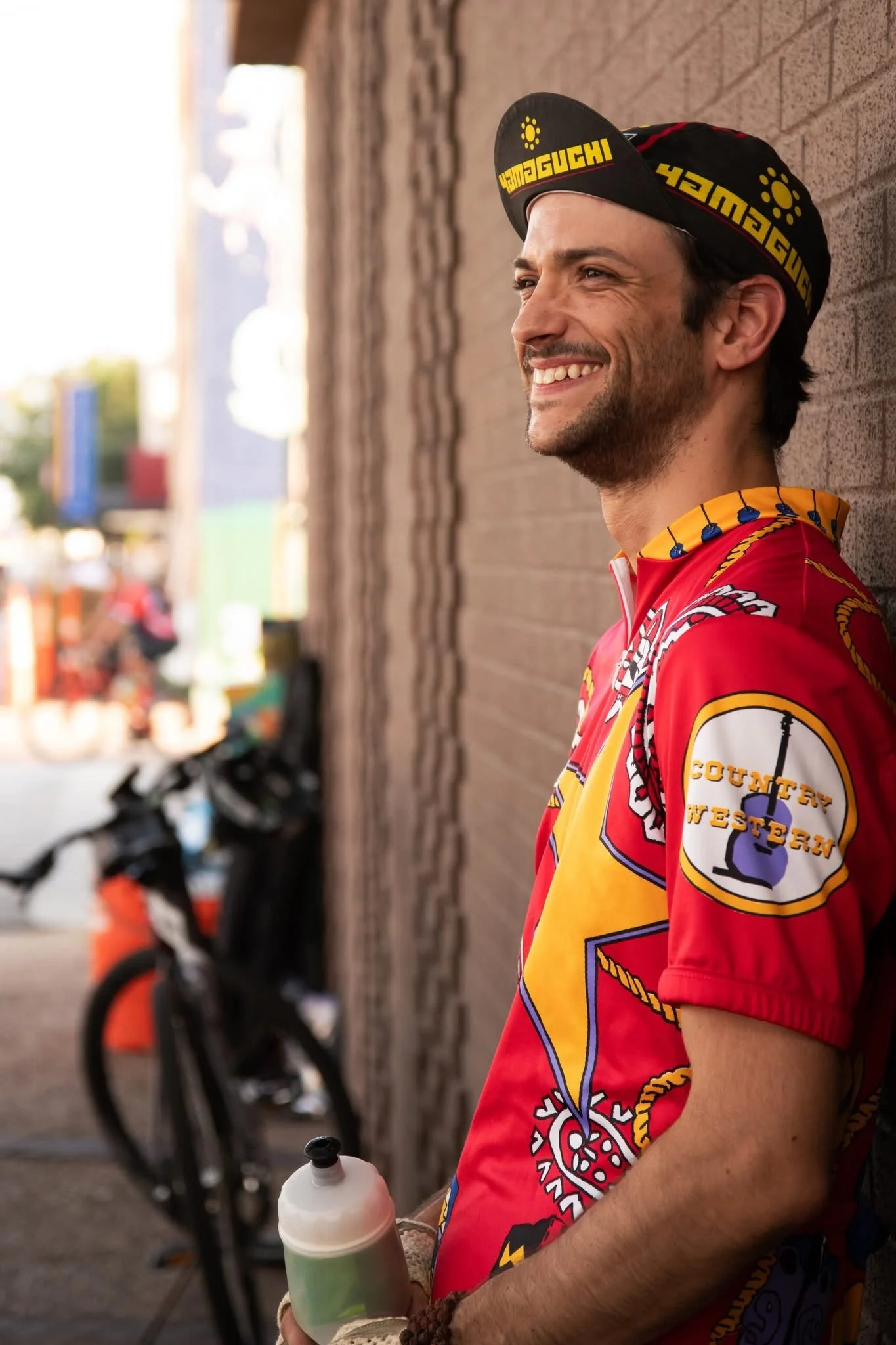 Austin with a bicycle against a brick wall